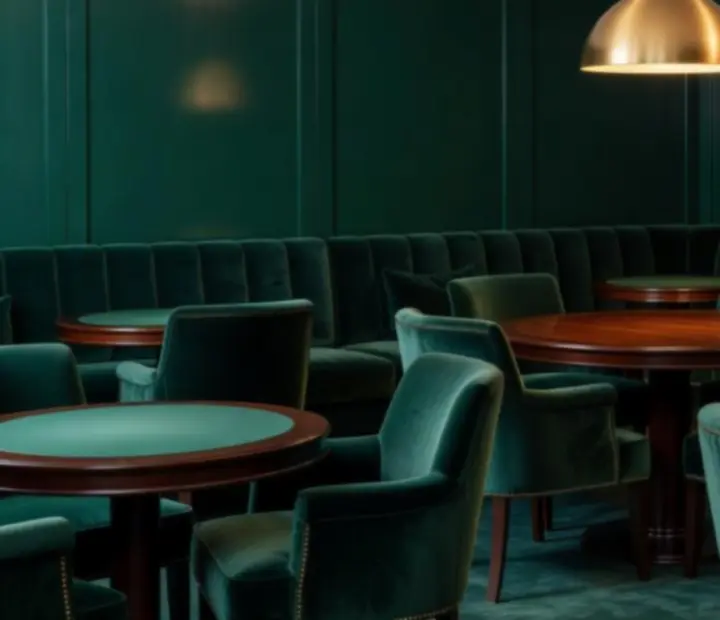 Interior of The Flop cardroom with velvet seating, banquettes and a central table under soft lighting